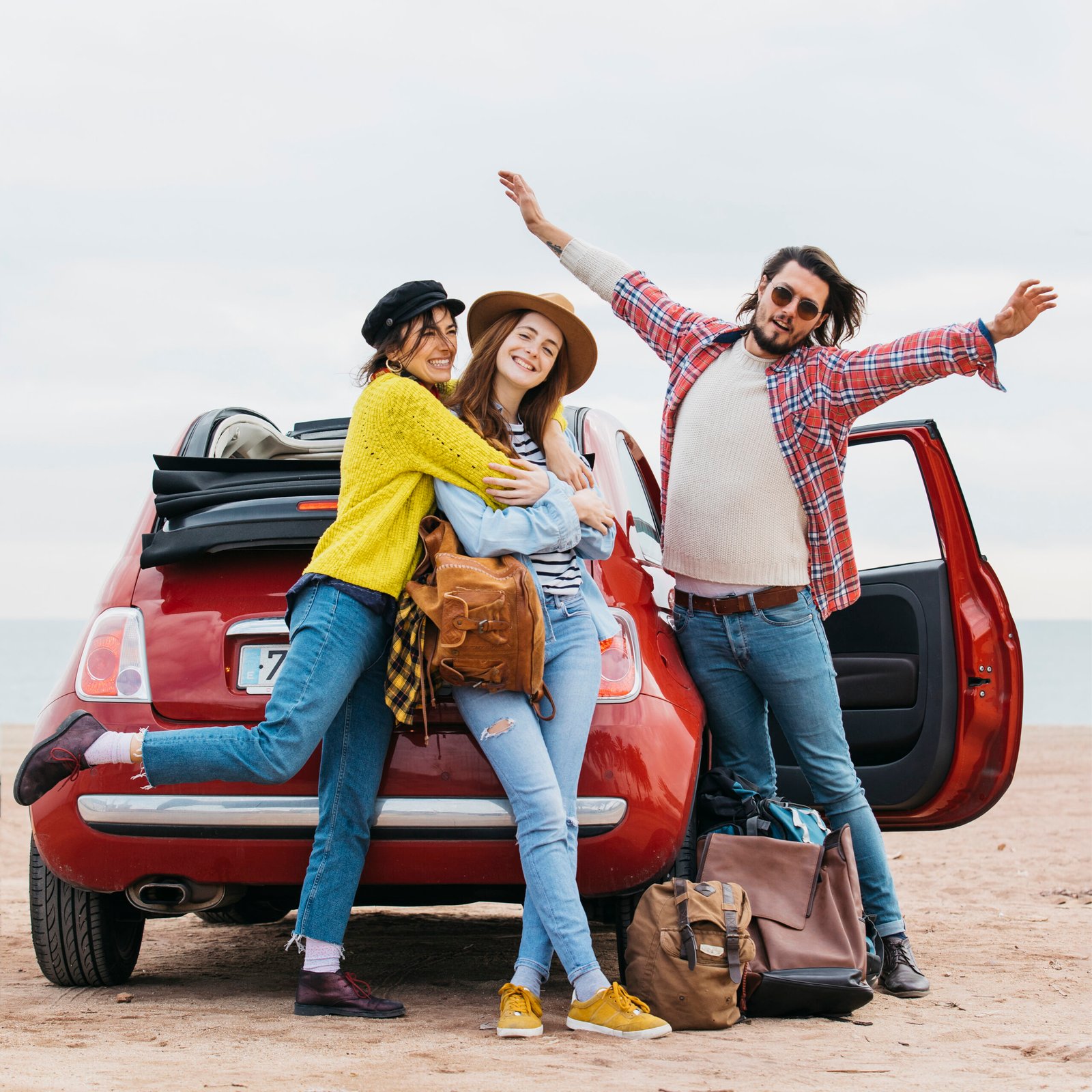 positive man with upped hands near embracing women car beach scaled